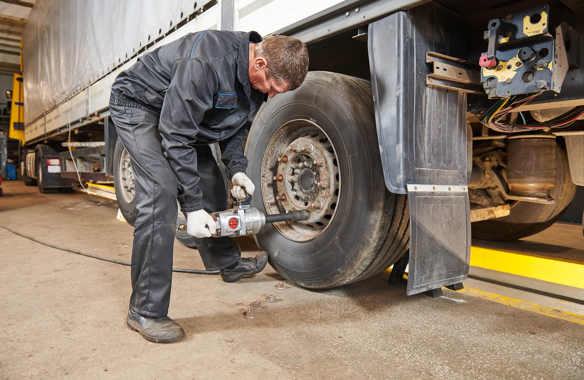 Mechanik przy kole ciężarowym w Gerex Serwis TIR
